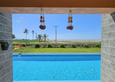 View of pool area with ocean in the background