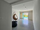 Spacious living area with large glass doors and a hanging chair