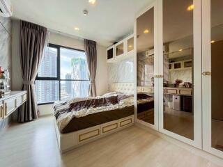 Contemporary bedroom with a large window and mirrored wardrobe