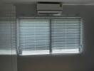 Bedroom with window blinds and air conditioning unit