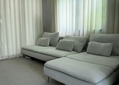 Modern living room with large sectional sofa and sheer curtains