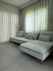 Modern living room with large sectional sofa and sheer curtains