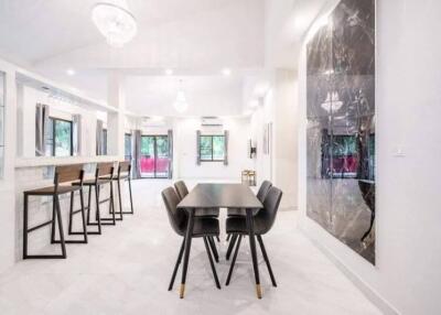 Modern dining area with black chairs and white marble surroundings