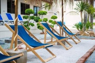 Outdoor lounging area with blue chairs and greenery