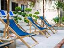 Outdoor lounging area with blue chairs and greenery