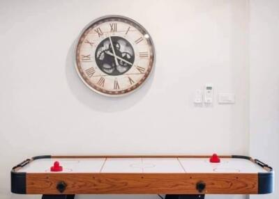 Game room with air hockey table and wall clock