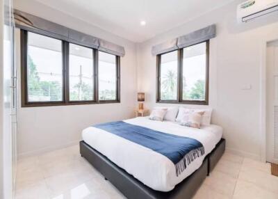 Bright bedroom with double bed and large windows