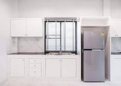 Modern kitchen with white cabinetry and a stainless steel refrigerator