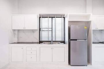 Modern kitchen with white cabinetry and a stainless steel refrigerator