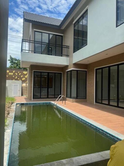 Backyard view featuring a swimming pool and modern house