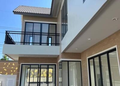 Modern two-story house exterior with large windows and pool