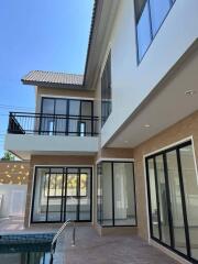 Modern two-story house exterior with large windows and pool