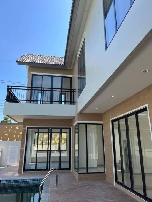 Modern two-story house exterior with large windows and pool