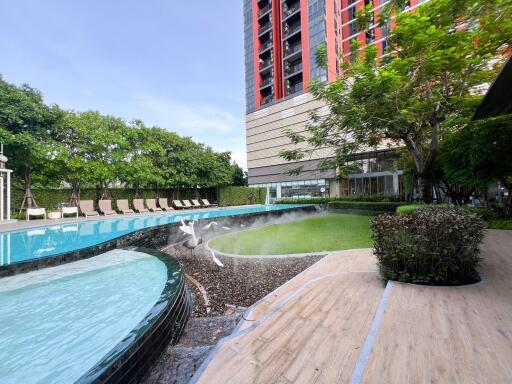 Outdoor pool area with building and greenery