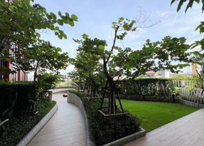 Well-maintained garden walkway with potted plants and trees