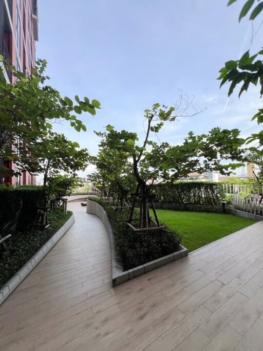 Well-maintained garden walkway with potted plants and trees