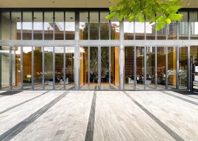 Modern building entrance with large glass doors and exterior patio area