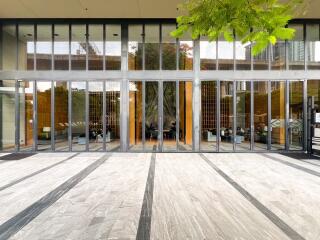 Modern building entrance with large glass doors and exterior patio area