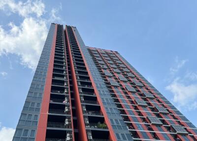 Modern high-rise apartment building with red and grey exterior