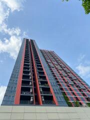 Modern high-rise apartment building with red and grey exterior