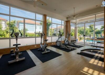 Modern home gym with exercise equipment and large windows