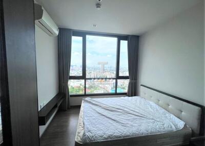 Spacious bedroom with a large window offering scenic views