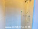 Shower area with tiled walls and electric water heater