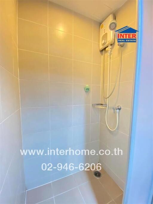 Shower area with tiled walls and electric water heater