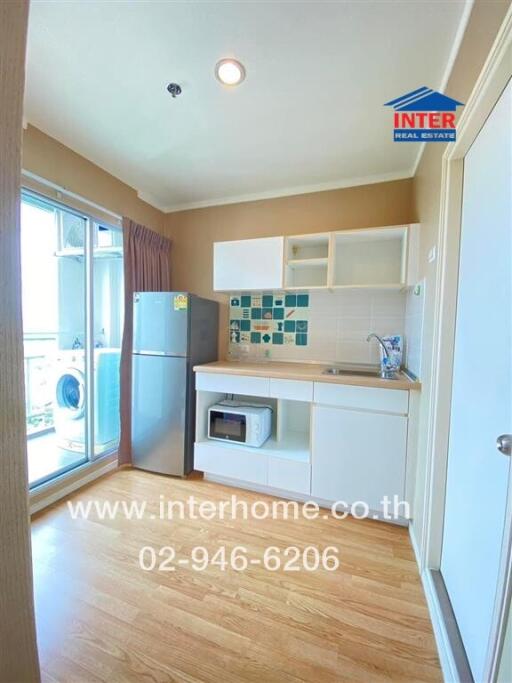 Modern kitchen with wooden floor, white cabinets, and appliances