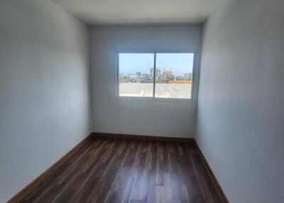 Empty bedroom with wooden floor and large window