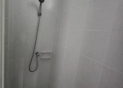 Shower with a handheld showerhead in tiled bathroom