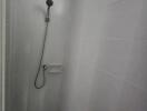 Shower with a handheld showerhead in tiled bathroom