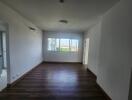 Spacious living room with wooden flooring and large window