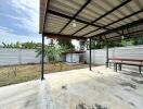 Covered patio with a bench and garden area