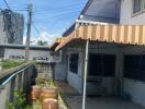 Exterior view of a building's backyard with garden and utility area