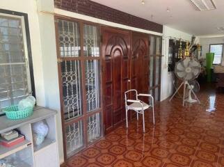 Spacious living area with large wooden doors and patterned flooring