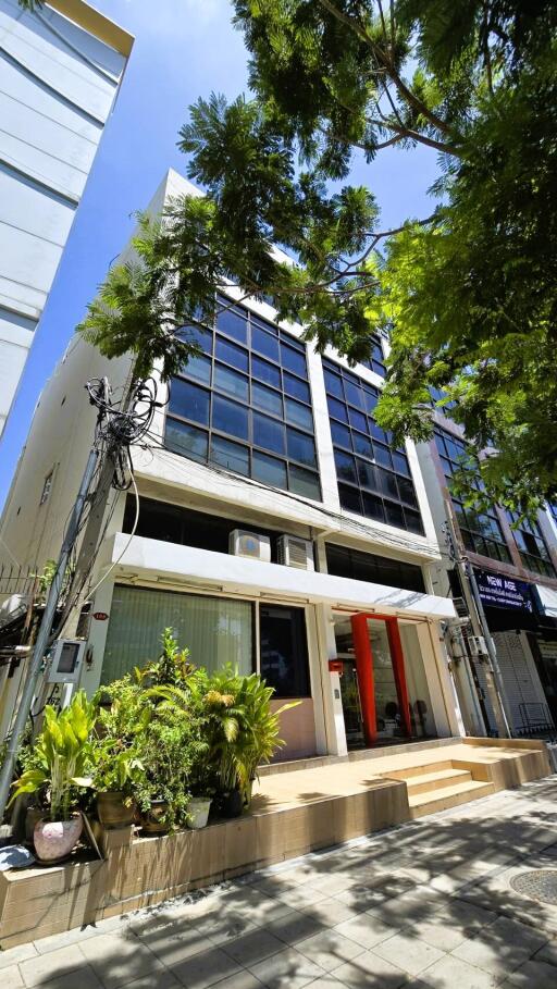 Modern office building with large windows and greenery