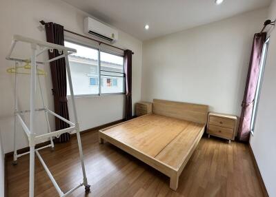 Spacious bedroom with wooden bed-frame and ample natural light