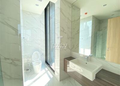 Modern bathroom with large window, marble walls, and freestanding sink