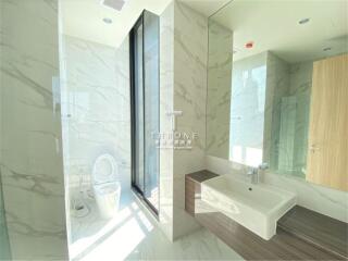 Modern bathroom with large window, marble walls, and freestanding sink