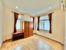 Bedroom with wooden flooring, large windows, wardrobe, and air conditioning