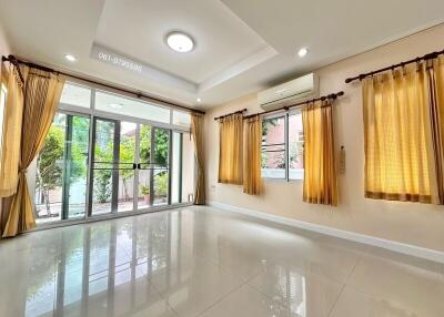 spacious living room with large windows and glass doors opening to a garden