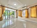 spacious living room with large windows and glass doors opening to a garden