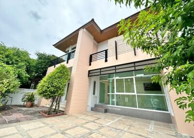 Modern two-story house with large windows and a balcony