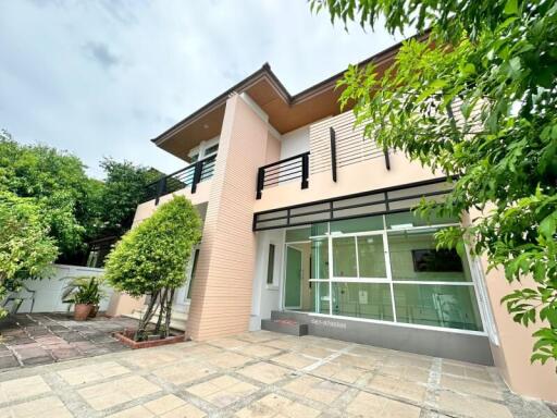 Modern two-story house with large windows and a balcony