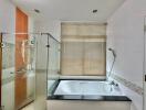 Spacious bathroom with bathtub and glass shower enclosure