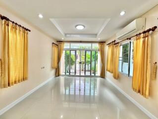 Bright and spacious living room with large windows and curtains