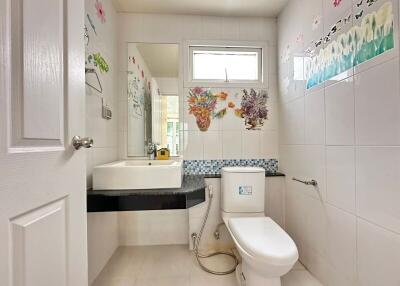 Clean and well-lit bathroom with decorative wall tiles