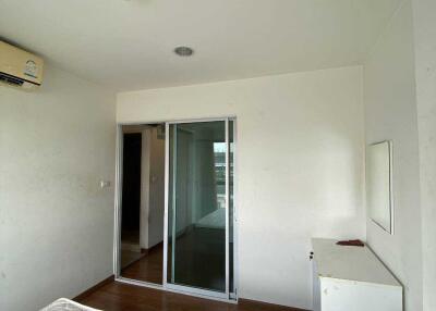 Bedroom with mattress, air conditioner, and glass door closet