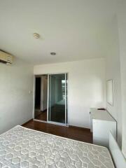 Bedroom with mattress, air conditioner, and glass door closet